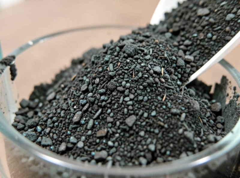 A bag of dark ADA Amazonia aqua soil granules poured into an empty rimless nano aquarium