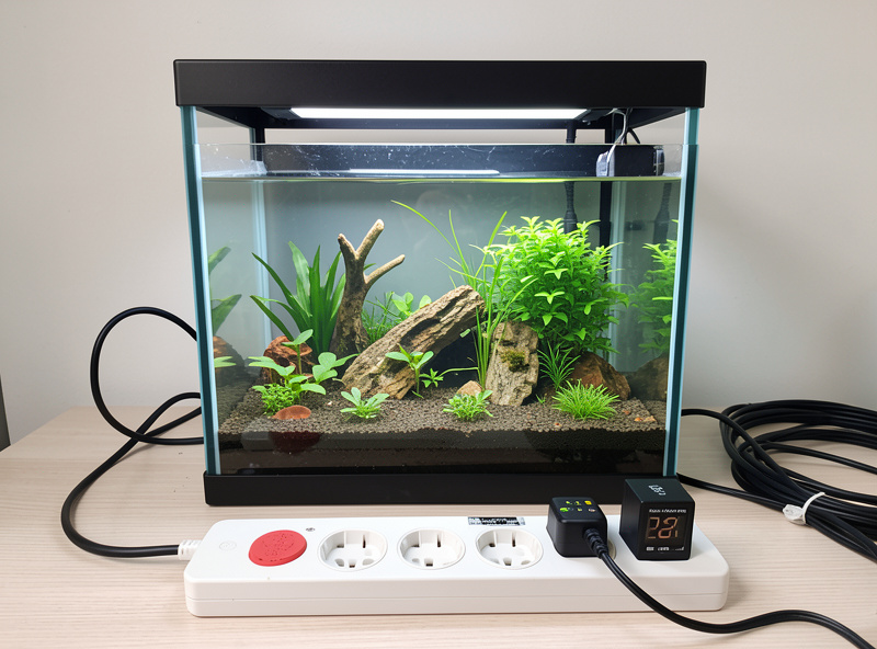 A nano planted aquarium with CO2 solenoid timer and light timer aligned on a power strip