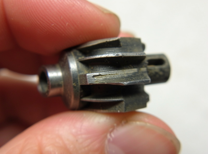 Worn aquarium filter impeller shaft held in fingers with fine groove wear on the ceramic pin