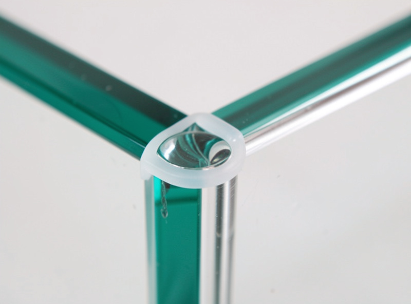 Macro of a rimless aquarium top corner showing a clean silicone-only glass joint with no plastic rim